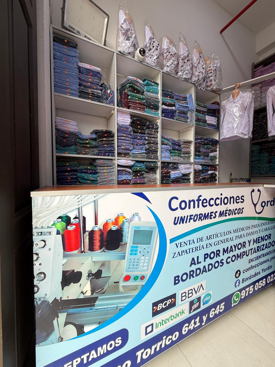 Interior de la tienda Confecciones Yordin con uniformes médicos